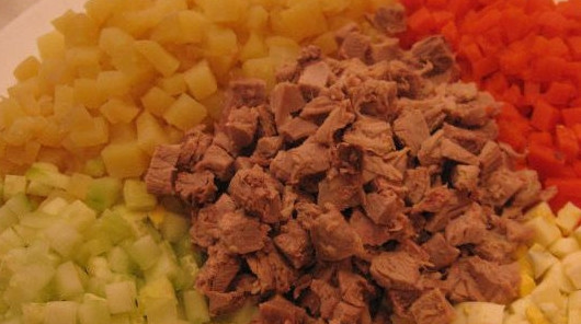 1. Этап. Салат Оливье с индейкой: Нарежьте мясо, огурцы, морковь, картошку и отварные яйца мелкими кубиками.