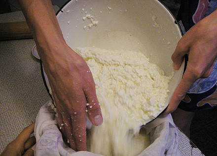 1. Этап. Сыр с дырками в домашних условиях: Снимаем кастрюлю с огня. Другую кастрюлю застилаем марлей, выливаем в нее нашу сырную массу. Концы марли завязываем, подвешиваем ее над раковиной, чтобы стекала сыворотка.