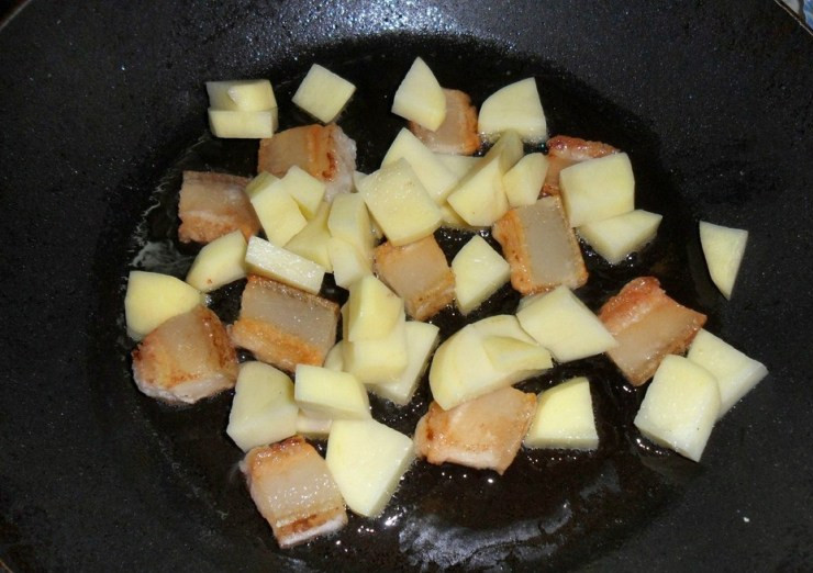 1. Этап. Бигус с грибами: Как только сало станет золотистого цвета и на сковороде будет достаточное количество жира, выкладываем на нее очищенный и нарезанный кубиками картофель, жарим его пару минут.