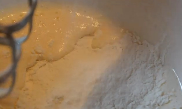 1. Этап. Отбивные в пышном кляре: 3. Просейте в кляр муку и завершите взбивать кляр миксером, чтобы он получился с пузырьками воздуха.