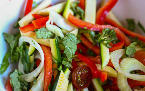 1. Этап. Камбала, запеченная с овощами: Подготовим овощи. Нарежем тонкими длинными ломтиками кабачок или цуккини, сладкий перец, морковь. Чеснок нарезаем мелкими пластинками, базилик рвем руками. Помидорки черри разрезаем пополам. Складываем все овощи в глубокую миску, поливаем соком половинки лимона, растительным маслом, добавляем соль и перец. Перемешиваем.