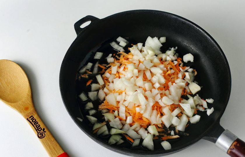 1. Этап. Борщ со стручковой фасолью: Пока овощи варятся приготовьте зажарку. Разогрейте сковороду с маслом и положите нарезанный кубиками лук и тертую морковь.
