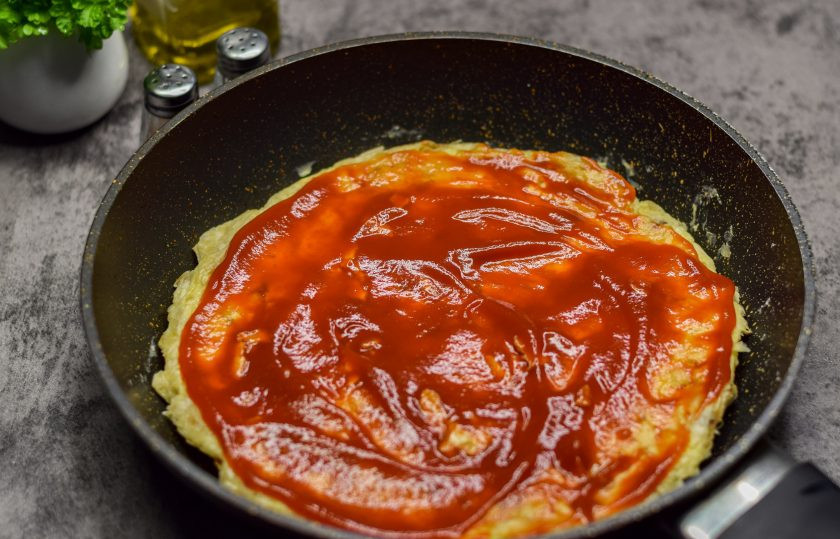 1. Этап. Быстрая пицца на сковороде из лаваша с яйцом: Переверните лаваш на обратную сторону, смажьте его кетчупом.