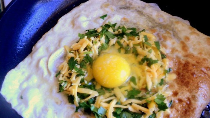 1. Этап. Конвертики из лаваша: Переверните лаваш, по центру выложите натертый сыр с зеленью, сделайте углубление и вбейте в него яйцо.