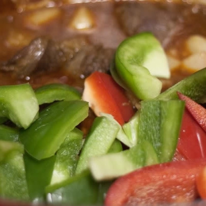 1. Этап. Гуляш из говядины: 10. Через час и десять минут добавьте в утятницу нарезанные кубиками болгарский перец и картошку (картошку предварительно очистите). Запекайте еще 30 минут.