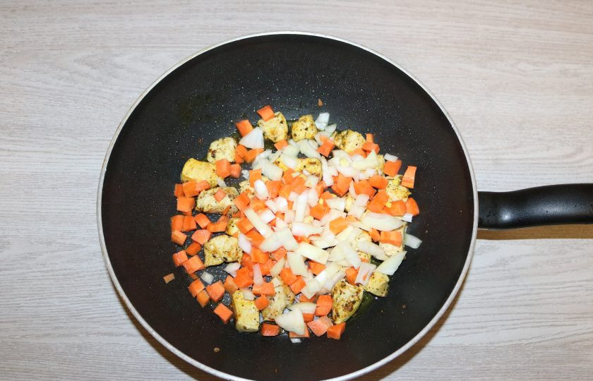 1. Этап. Рис с курицей и фасолью: К курице добавьте лук и морковь, обжаривайте вместе на среднем огне.