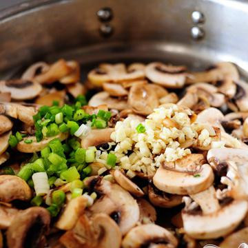 1. Этап. Бифштекс в грибном соусе: Когда масло растает, бросьте в сковородку грибы, лук и чеснок.