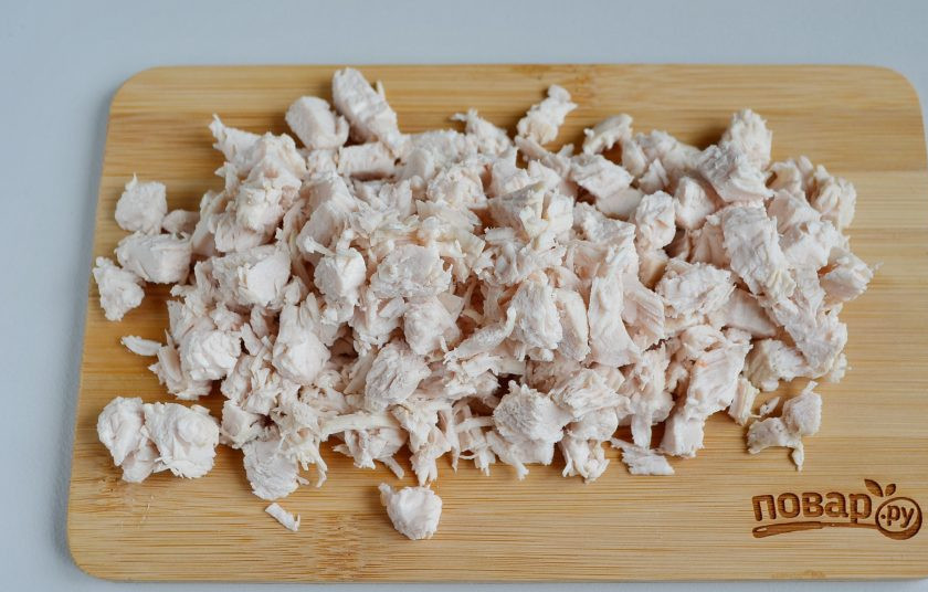 1. Этап. Слоеный салат из хурмы: Филе разберите на волокна или порежьте кубиками.