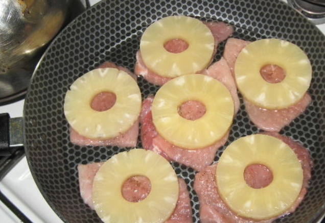 1. Этап. Свиные отбивные с сыром: Нарезаем свинину порционными кусочками, слегка отбиваем, перчим и солим. Перекладываем в форму для запекания. Сверху кладем кольца ананаса.