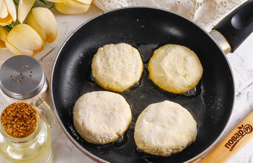 1. Этап. Сырники из творога с корицей: Разогрейте растительное масло в сковороде и убавьте нагрев до умеренного. Выложите в масло заготовки и обжарьте минуту с одной стороны.