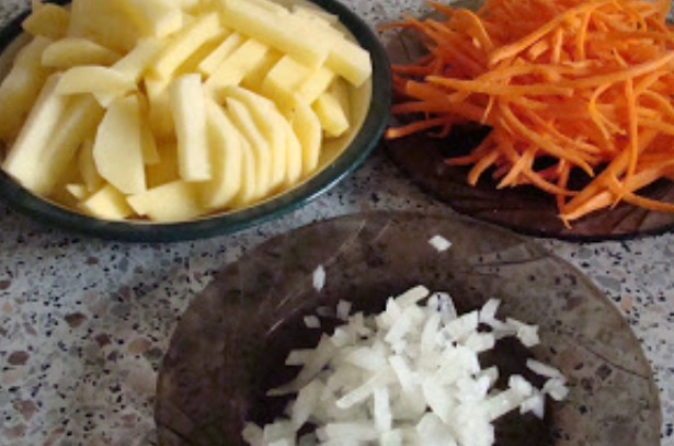 1. Этап. Суп с куриными потрохами: Овощи моем, чистим. Картофель нарезаем ломтиками, морковь трем на терке, а лук измельчаем.