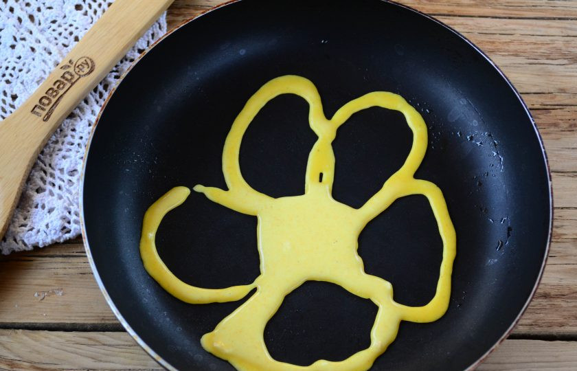 1. Этап. Малазийские кружевные блины Роти Джала: Чтобы сделать блины кружевные, можно использовать бутылку: просто налейте тесто в бутылку, в крышечке сделайте отверстие и через него выливайте тесто, рисуя красивый узор. Можно также использовать кондитерский мешок и подходящую насадку или же плотный пакет, в уголке которого нужно сделать небольшой надрез. Я использовала кондитерский мешок. Сковороду хорошо разогрейте, смазывать не нужно, поскольку в самом тесте уже есть масло. Нарисуйте тестом узор на сковороде (например, цветочек, но так, чтобы все лепестки были связаны и не было пробелов). Жарьте ажурные блины, как обычно: минуту на одной стороне и минуту — на второй.