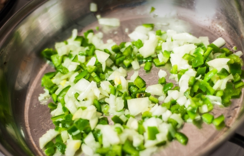 1. Этап. Мясо по-испански: Пока мясо жарится, нарубите мелко репчатый лук и болгарский перец. Не забудьте очистить болгарский перец от семян. Обжарьте овощи так же на оливковом масле в отдельной сковороде.