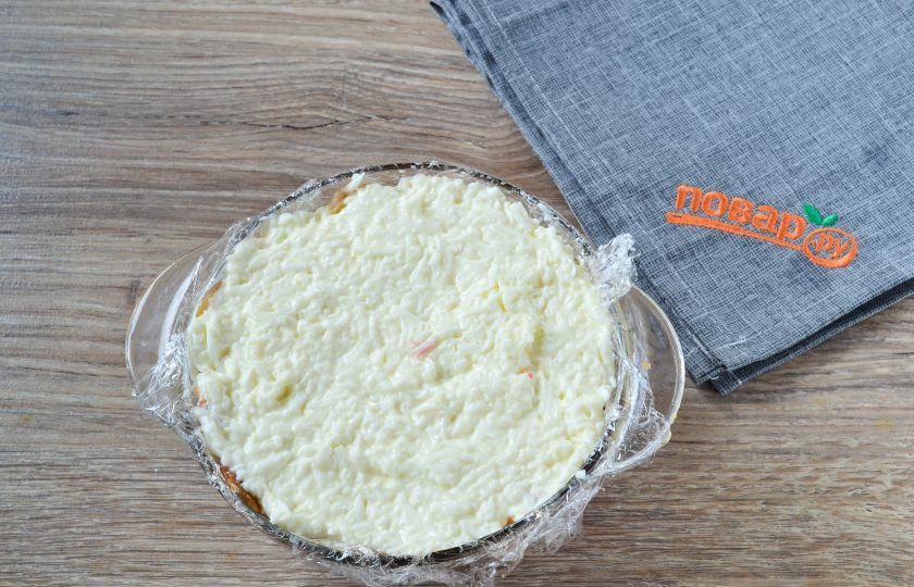 1. Этап. Закусочный торт с крабовой начинкой: И в последнюю очередь выложите и распределите ровным слоем белковую массу. Отправьте торт в холодильник на 4 часа до полного застывания.