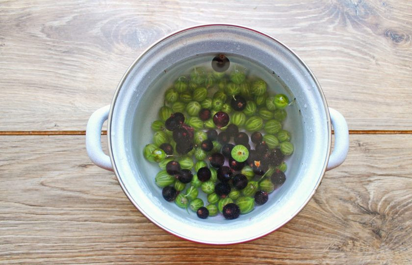 1. Этап. Компот из смородины и крыжовника: У смородины удалите веточки. Добавьте ягоды в кастрюлю с крыжовником. Доведите компот до кипения и варите в течение 2 минут.
