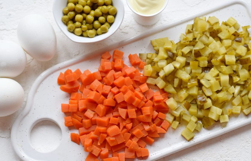 1. Этап. Салат Столичный с яблоком: Вареную морковь нарежьте аналогично картофелю. Соленые огурцы нашинкуйте небольшими кубиками. Если при нарезке огурцов выделилось много сока, слейте его.