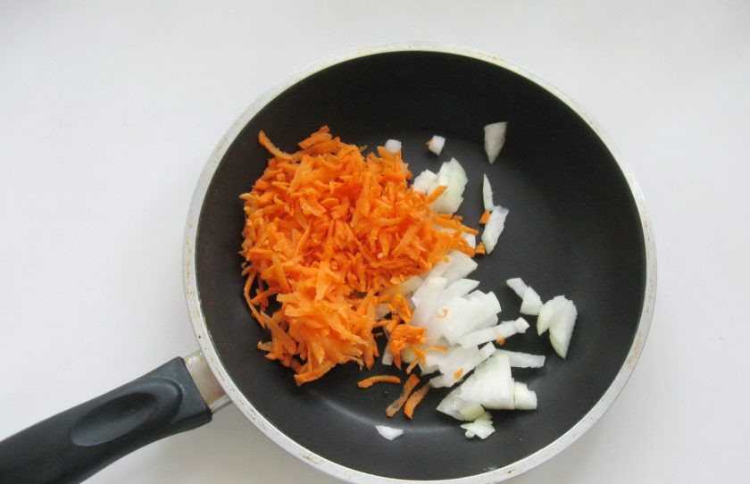 1. Этап. Куриные зразы с морковью и сыром: Одну небольшую луковицу и маленькую морковь очистите, помойте. Лук мелко нарежьте, а морковь натрите на терке. Выложите в сковороду и налейте 20 мл рафинированного подсолнечного масла.