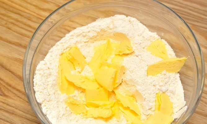 1. Этап. Быстрый лимонный пирог: 2. Порубите небольшими кусочками холодное сливочное масло и добавьте в муку.