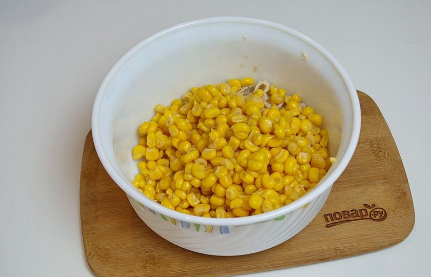 1. Этап. Салат 8 Марта с кальмарами: Кукурузу консервированную извлеките из банки, предварительно слив воду.