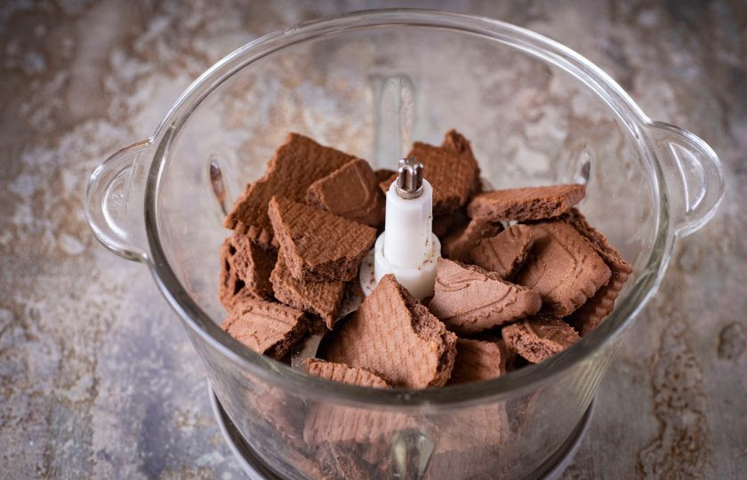 1. Этап. Шоколадный чизкейк с выпечкой: Печенье поломайте произвольными кусочками и выложите в чашу блендера.