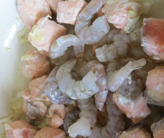 1. Этап. Спагетти с чернилами каракатицы в сливочном соусе: К луку добавить креветки и семгу. Обжаривайте в течение 10 минут, постоянно перемешивая. После 10-и минут добавьте сливки и оставить еще на 10 минут тушиться под крышкой на среднем огне.