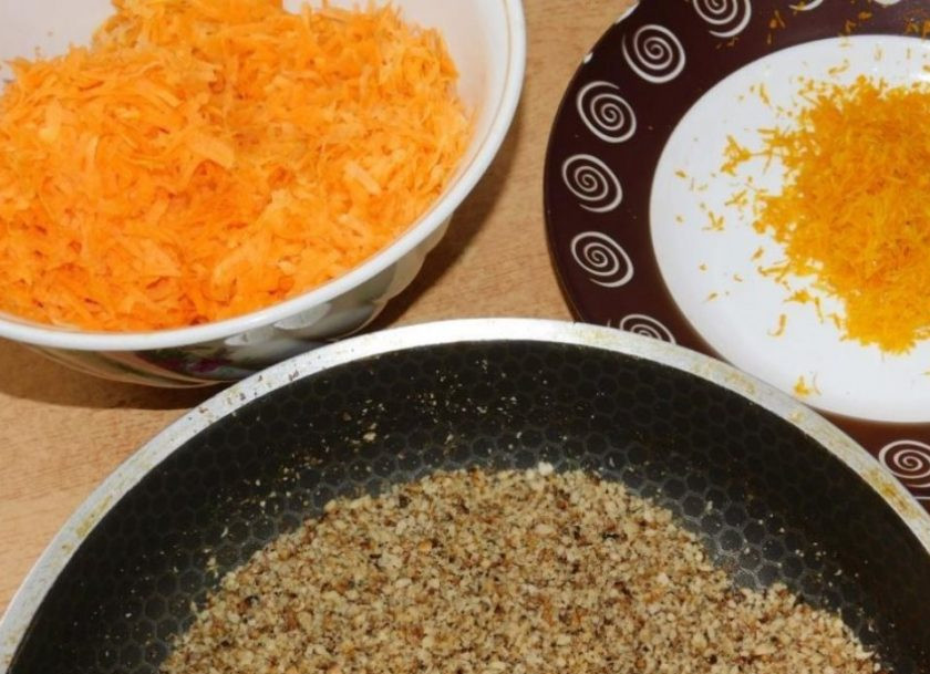 1. Этап. Морковный бисквит с орехами: Орехи немного порубите ножом и обжарьте. С апельсина снимите цедру. Морковь натрите на мелкой терке.