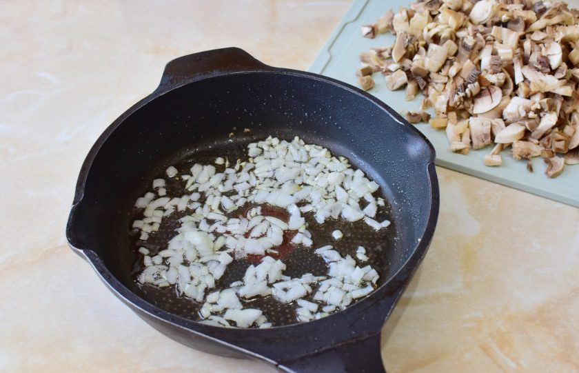 1. Этап. Салат Восторг с корейской морковью: Лук очистите и мелко нарежьте. Грибы промойте от загрязнений, обсушите и измельчите. Обжарьте 2-3 минут лук. Затем добавьте в сковороду грибы. Обжаривайте все вместе 7-10 минут.