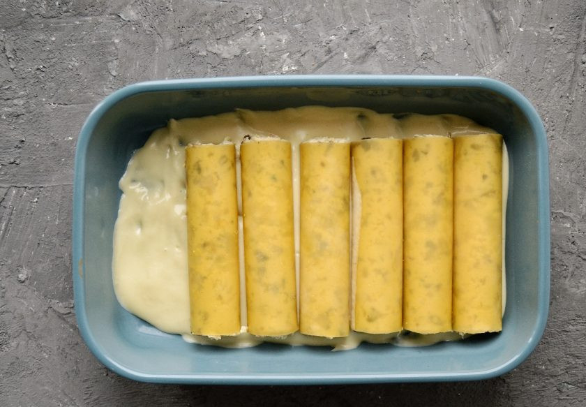 1. Этап. Вегетарианские каннеллони: Вылейте 1/3 сливочного соуса из кешью в форму для запекания. Уложите каннеллони поверх соуса.