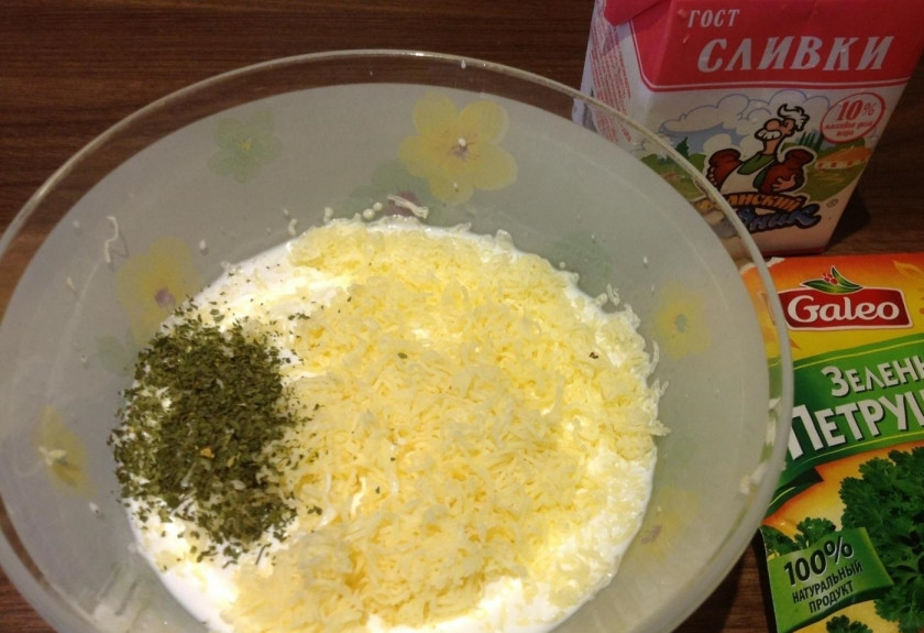 1. Этап. Фрикадельки под соусом в духовке: 9. Сыр измельчаю, добавляю к нему мелко рубленный чеснок и сухую зелень, солю и вливаю сливки, перемешиваю.