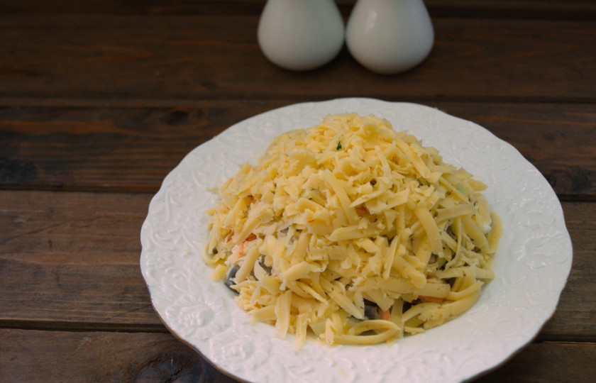 1. Этап. Салат Орхидея с курицей: Натрите на терке твердый сыр. Выложите поверх всей полусферы.