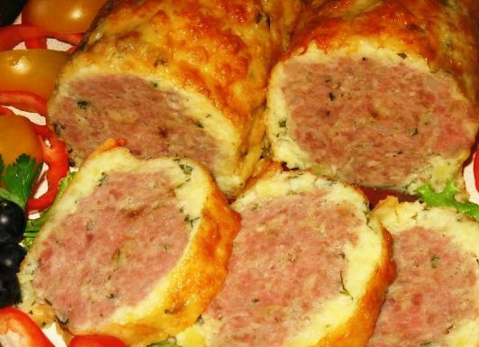 1. Этап. Мясной рулет в картофельной оболочке: Вкусный рулет готов, можно пробовать. Нарезаем его острым ножом кусочками, украшаем блюдо зеленью, оливками и овощами. Приятного аппетита!