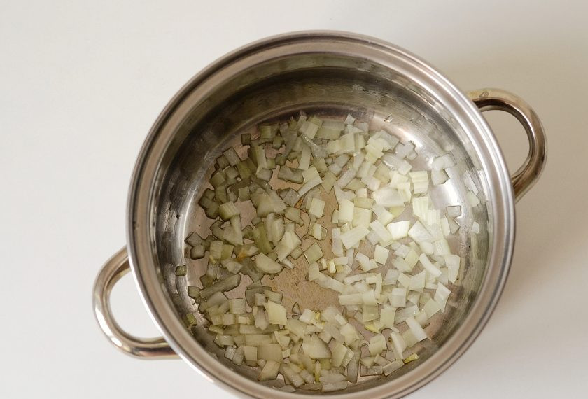 1. Этап. Карибский суп: Лук нарежьте мелкими кубиками и обжарьте в кастрюле до мягкости.