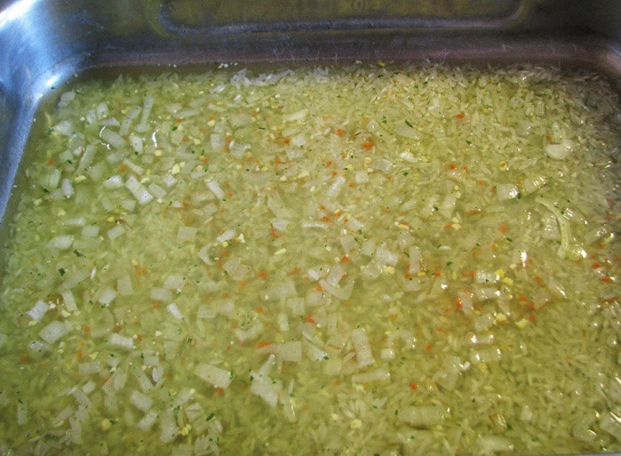 1. Этап. Ленивый рис с курицей: Берем глубокий противень, смазываем маслом, выкладываем рис. Сверху - обжаренный лук.