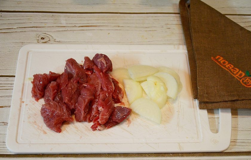 1. Этап. Говядина, жареная на сковороде: 1. Говядину промойте, нарежьте кусочками. Лук нарежьте полукольцами.