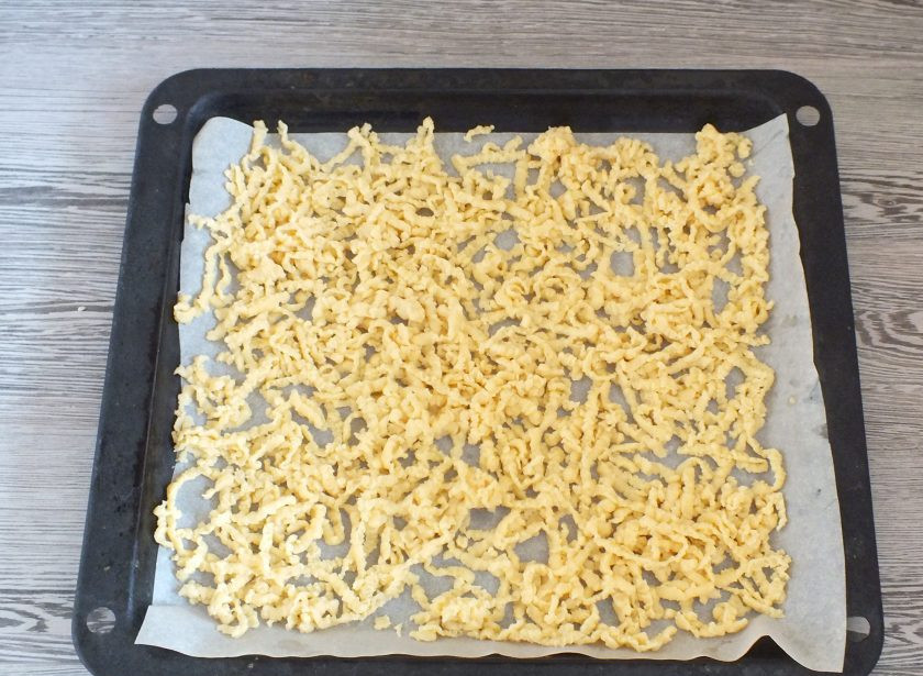 1. Этап. Печенье Ласточкино гнездо: Возьмите противень, застелите его пергаментом. По истечении времени, достаньте тесто из морозилки. Разделите на две части. Обе части натрите на крупной терке. Поставьте противень в разогретую до 180 градусов духовку на 15 минут. Тесто должно слегка зарумяниться и полностью пропечься. Готовую заготовку из теста охладите.