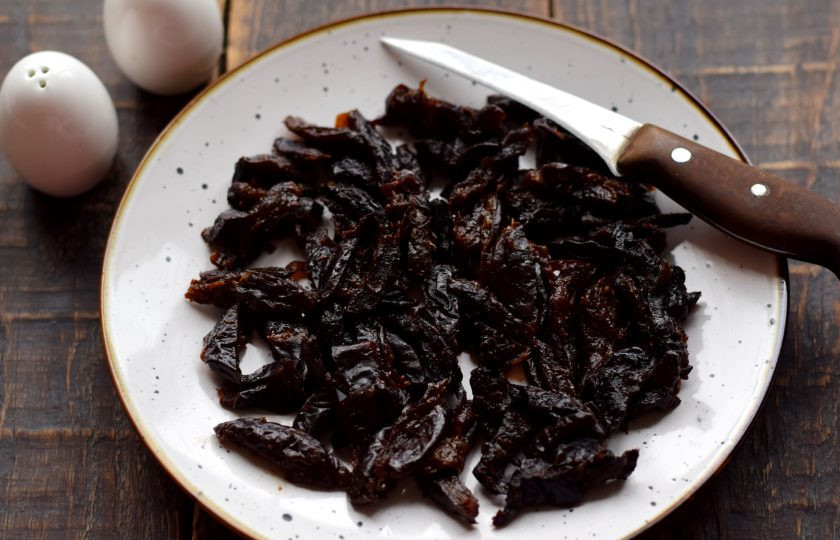 1. Этап. Салат с курицей, пекинской капустой и черносливом: Мягкий чернослив нарежьте одинаковыми полосками. Очень твердый чернослив необходимо заранее распарить в кипятке до мягкости, затем просушить и нарезать.