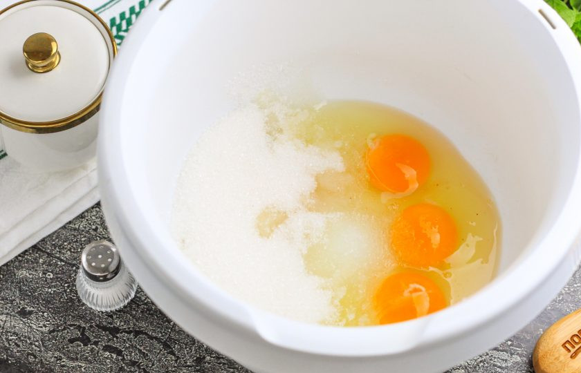 1. Этап. Пирог на сливочном масле: Куриные яйца вбейте в емкость миксера или кухонного комбайна. Всыпьте соль и сахарный песок. Взбейте на самой высокой скорости техники примерно 4 минуты в пышную пену.