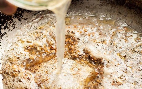 1. Этап. Рецепт пасты с курицей: 3. Влейте в сковороду вино и сок одного лимона, выпаривайте жидкость около 2-3 минут до ее уменьшения в 2 раза.