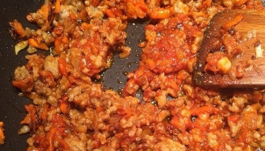 1. Этап. Гречка по-купечески с фаршем: На второй сковороде пассеруйте морковь и лук на рафинированном подсолнечном масличке. Для этого натрите морковку на терке, а лук нарежьте как можно мельче. Когда овощи приобретут желтый оттенок, добавьте к ним томатную пасту и фарш. Перемешайте и обжаривайте около пяти минут.