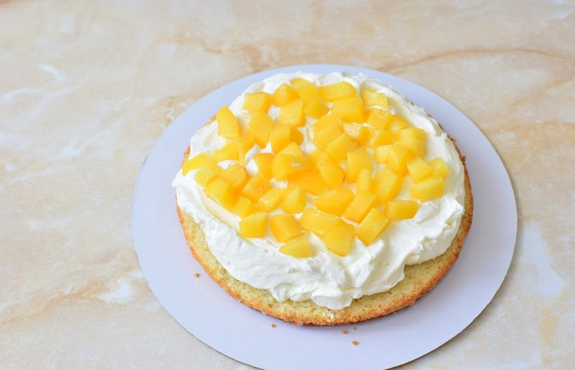 1. Этап. Торт с консервированными персиками и взбитыми сливками: Бисквитные коржи пропитайте сиропом от персиков. Смазывайте коржи кремом и выкладывайте нарезанные персики.