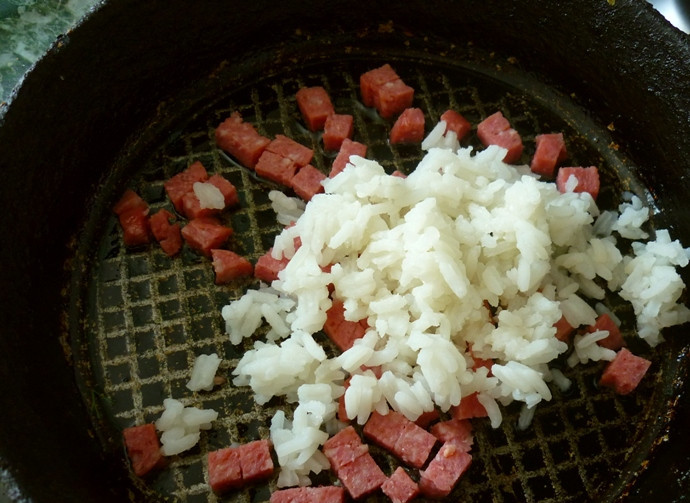 1. Этап. Омлет с рисом: Наливаем в сковороду небольшое количество растительного масла и ставим на огонь. Колбасу нарезаем небольшими кубиками и обжариваем пару минут, добавляем отваренный рис.