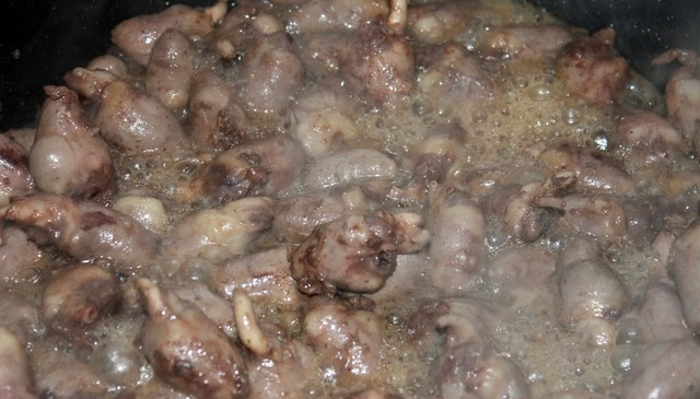 1. Этап. Куриные сердечки в сливках: Ставим сковороду на огонь и выкладываем на нее сердечки, масла добавлять не надо, так как они пустят много сока, поэтому делаем маленький огонь и жарим сердечки в течение 25-30 минут.