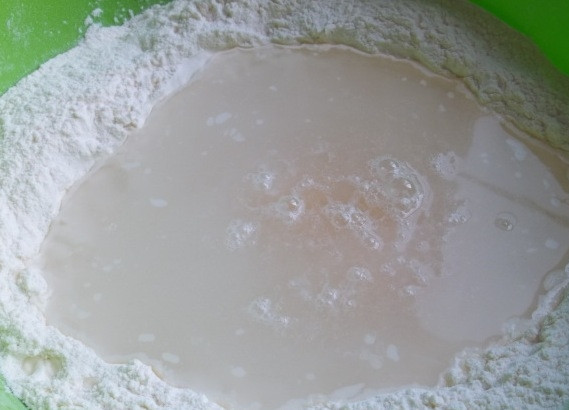 1. Этап. Тесто для хинкали: Налейте в углубление теплую воду.