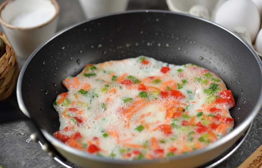 1. Этап. Корейский омлет: Смажьте небольшую сковороду растительным маслом, вылейте немного белка с овощами, жарьте на тихом огне около минуты.