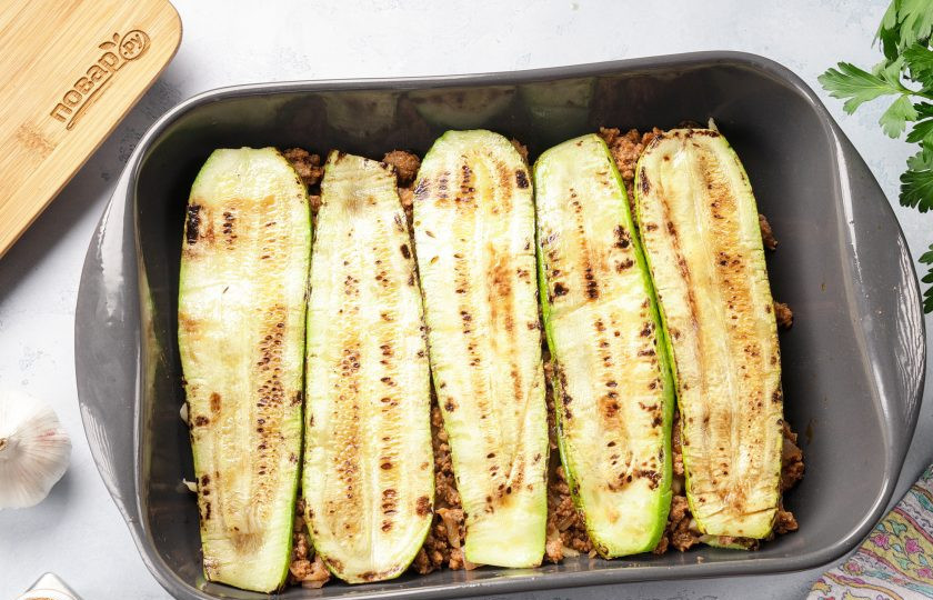 1. Этап. Кето-лазанья с кабачком: На фарш выложите слой кабачков. Посолите, поперчите и посыпьте сыром. Снова выложите фарш, а на фарш оставшиеся кабачки.