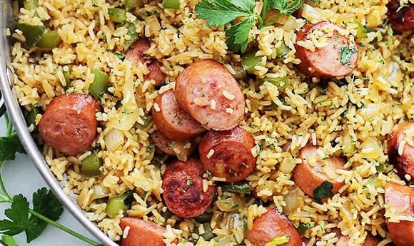 1. Этап. Рис с сосиской: 4. Выложите готовый рис, верните на сковороду сосиски. Добавьте соль и перец по вкусу. Аккуратно все перемешайте.