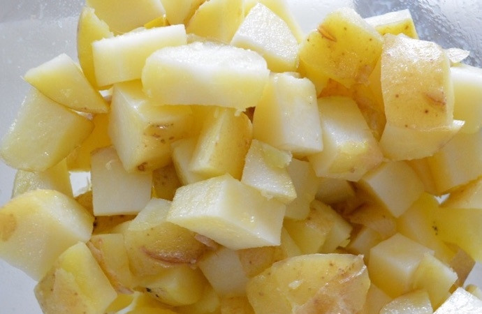 1. Этап. Салат из картофеля и кукурузы: 3. Переложите картофель в миску, добавьте оливковое масло, перемешайте и оставьте на 20 минут.