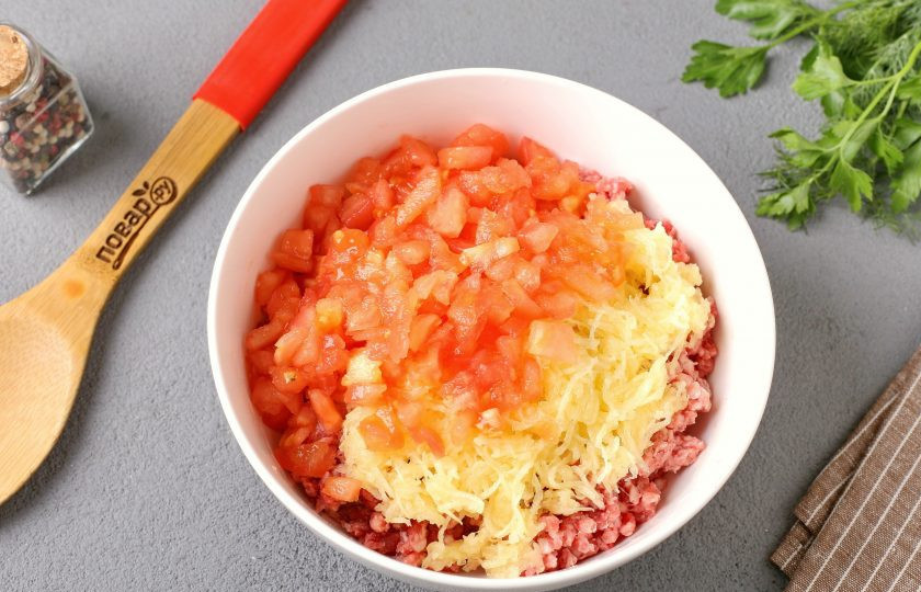 1. Этап. Котлеты с кабачком и помидором: Кабачок натрите на мелкой тёрке, добавьте щепотку соли, перемешайте и оставьте на 10 минут. Затем хорошо отожмите и добавьте к фаршу. У помидора сделайте с двух сторон надрезы ножом, ошпарьте кипятком, снимите шкурку, а мякоть нарежьте мелкими кубиками. Добавьте к кабачку с фаршем.