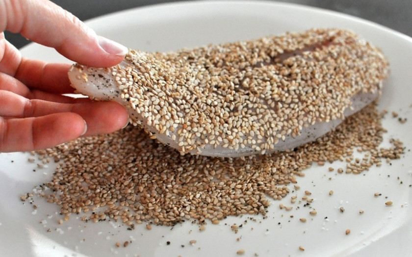 1. Этап. Рыба в кунжуте: Обваляйте кусок рыбы в кунжуте со всех сторон.