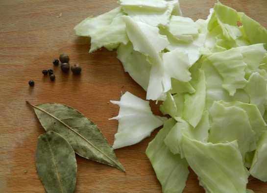 1. Этап. Картофельный суп-толчeнка с квашеной капустой: 3. Добавляем к овощам лавровый лист, перец и порванные капустные листья. Заливаем водой и варим на небольшом огне минут 20-30.